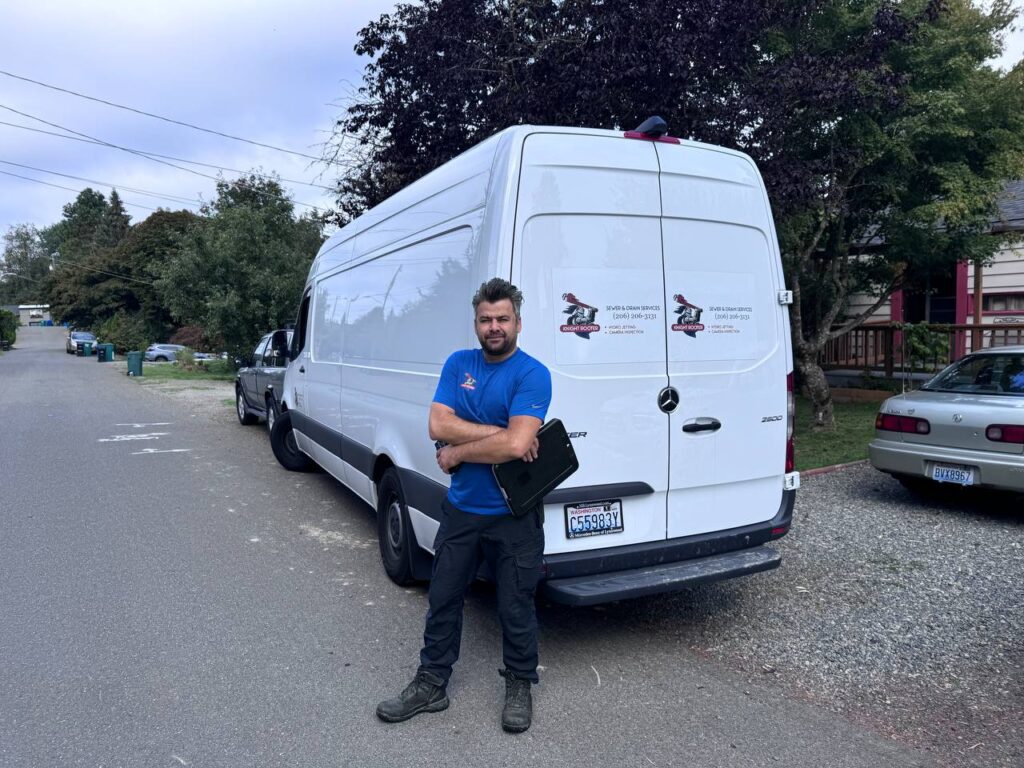 A Knight Rooter technician stands by a white service van on a street